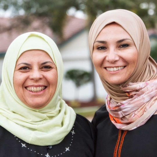 Two muslim women smiling outdoors